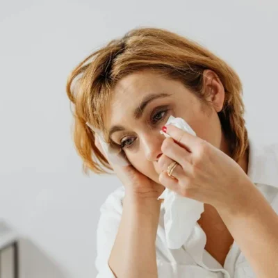 mujer secándose las lagrimas con un pañuelo