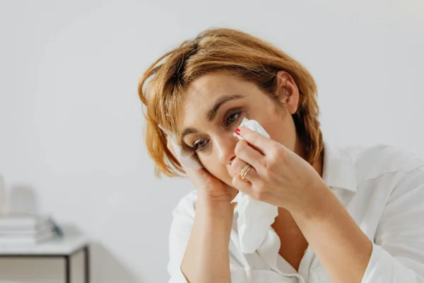 mujer secándose las lagrimas con un pañuelo
