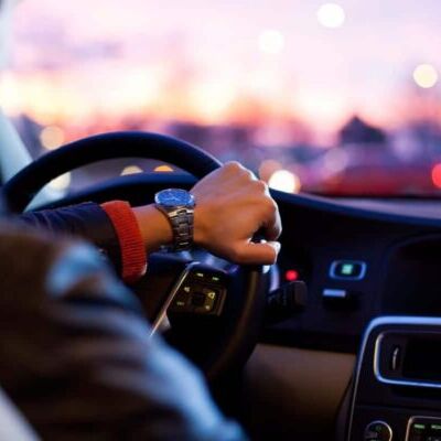 hombre en un coche conduciendo agarrado al volante.