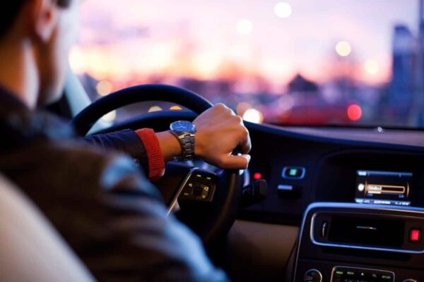 hombre en un coche conduciendo agarrado al volante.